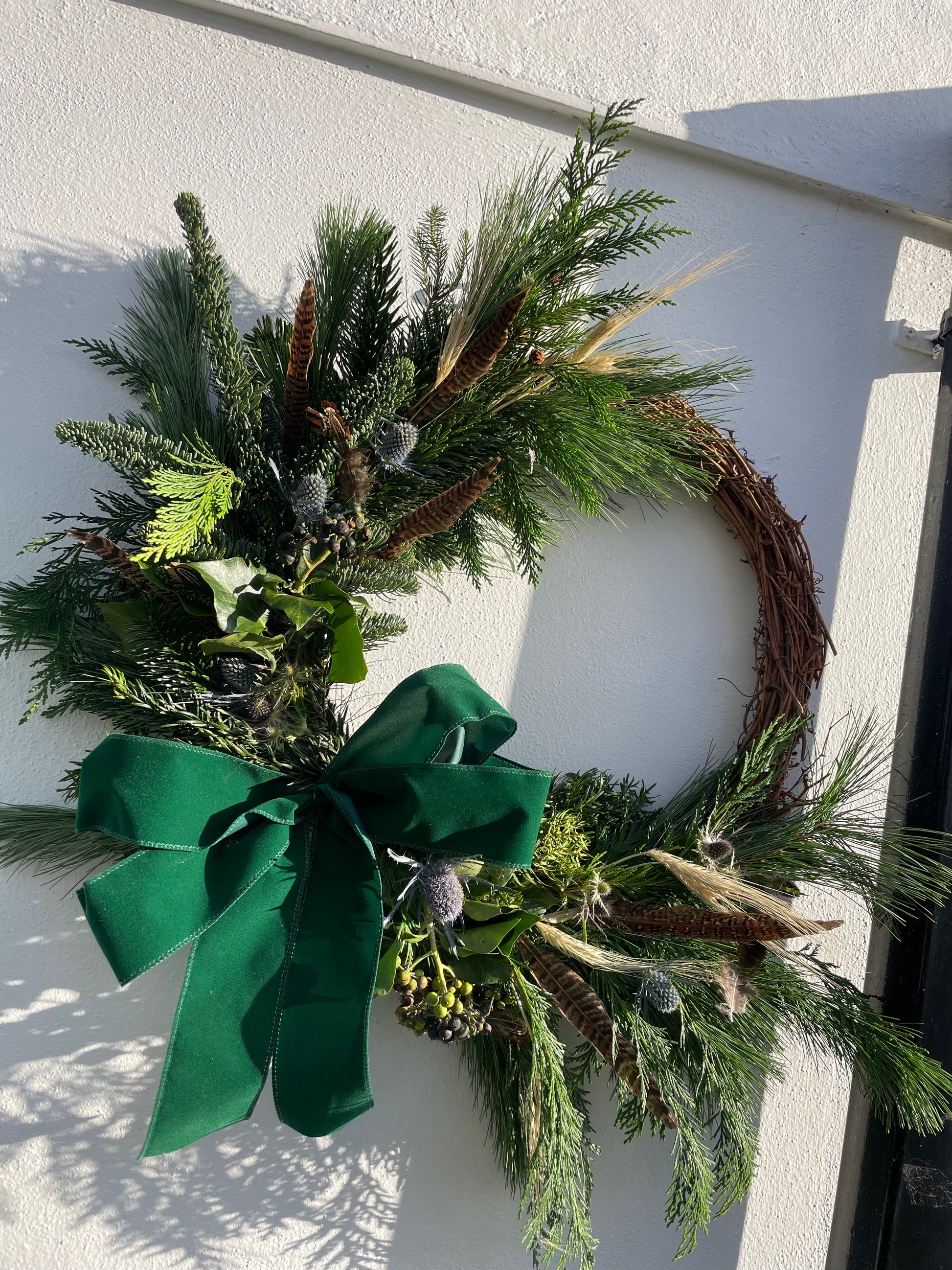 The Elf Wreath – handmade Christmas wreath with spruce, eryngium, and velvet ribbon by Barns Florals.