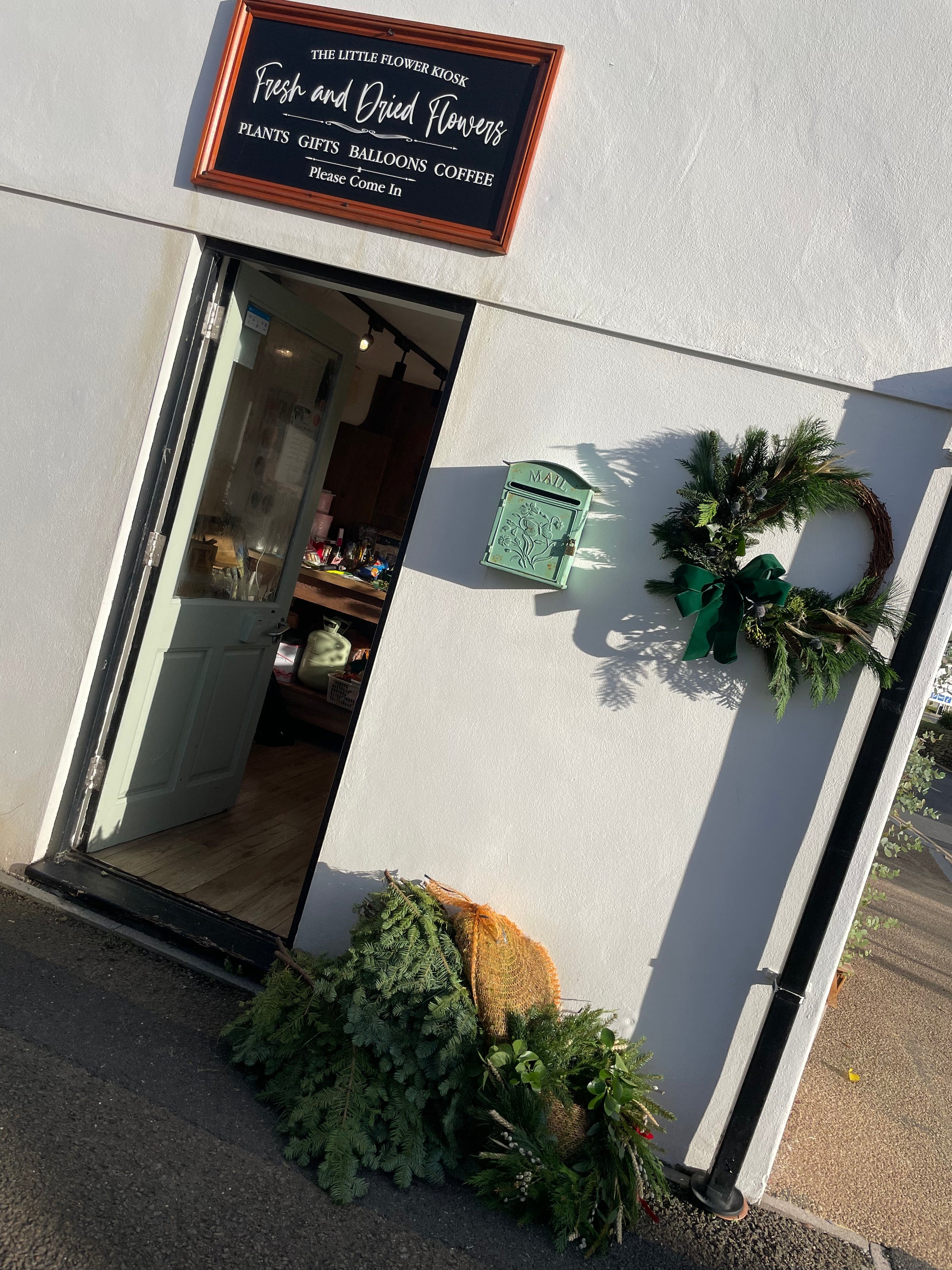 The Elf Wreath styled on a front door – festive handmade design with velvet bow by Barns Florals Cornwall