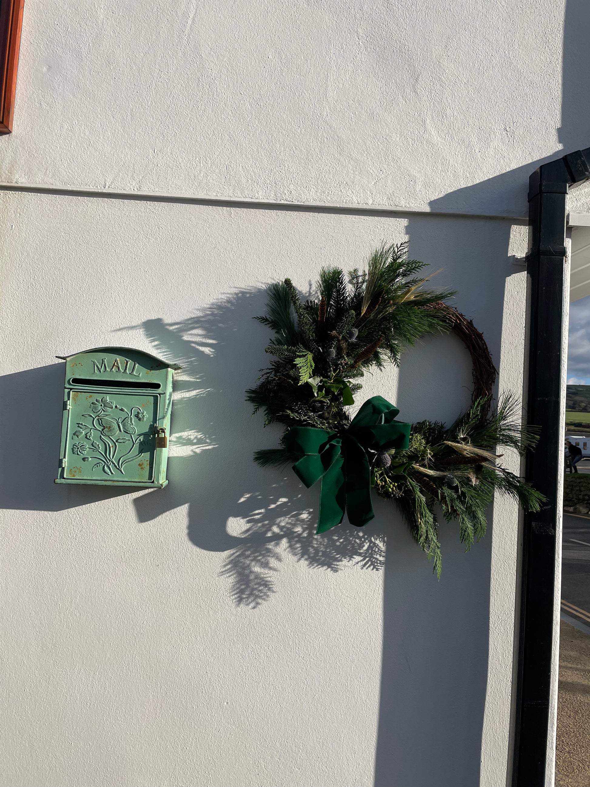 The Elf Wreath styled on a front door – festive handmade design with velvet bow by Barns Florals Cornwall