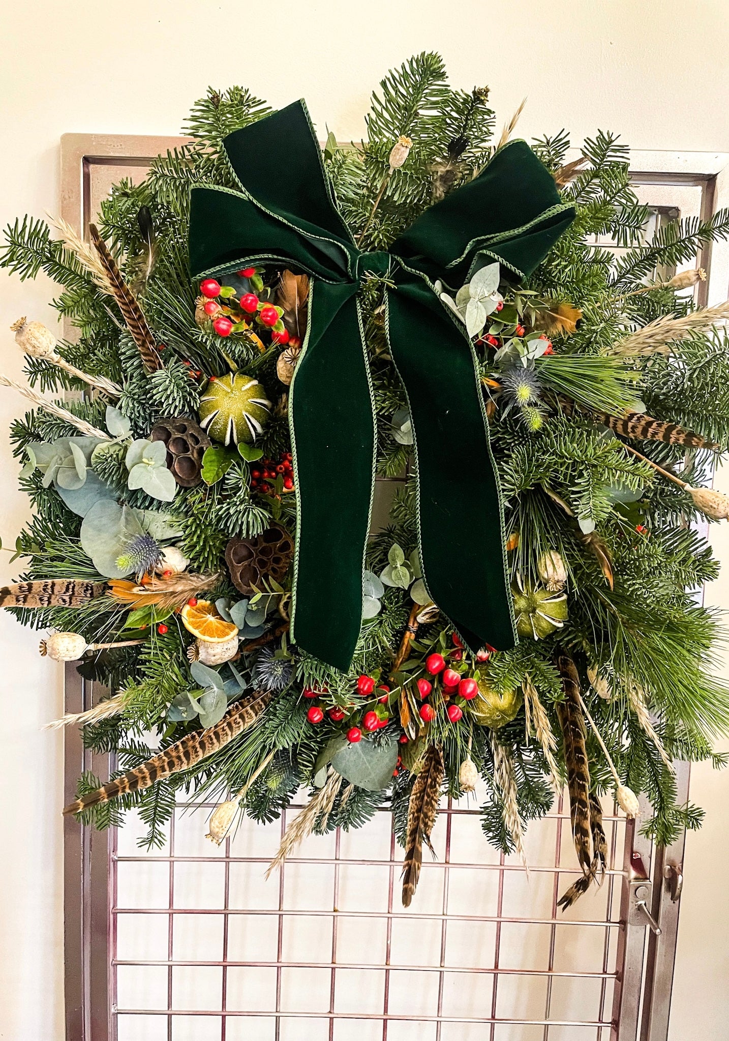 Feathers & Berries Wreath styled on a front door – festive handmade design by Barns Florals.”