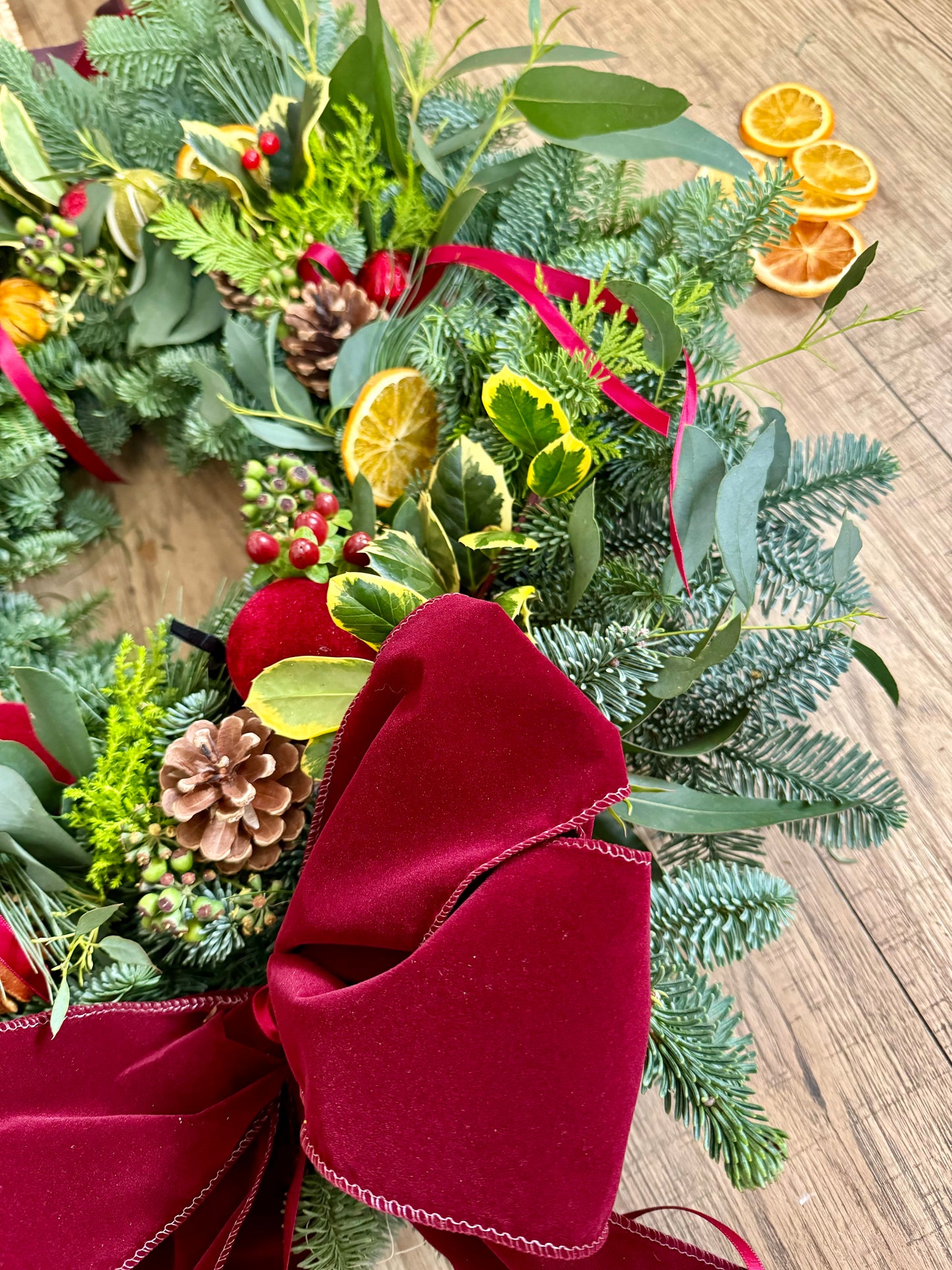 Luxury fresh and dried Christmas wreath with layered foliage and velvet ribbon – Barns Florals Cornwall.