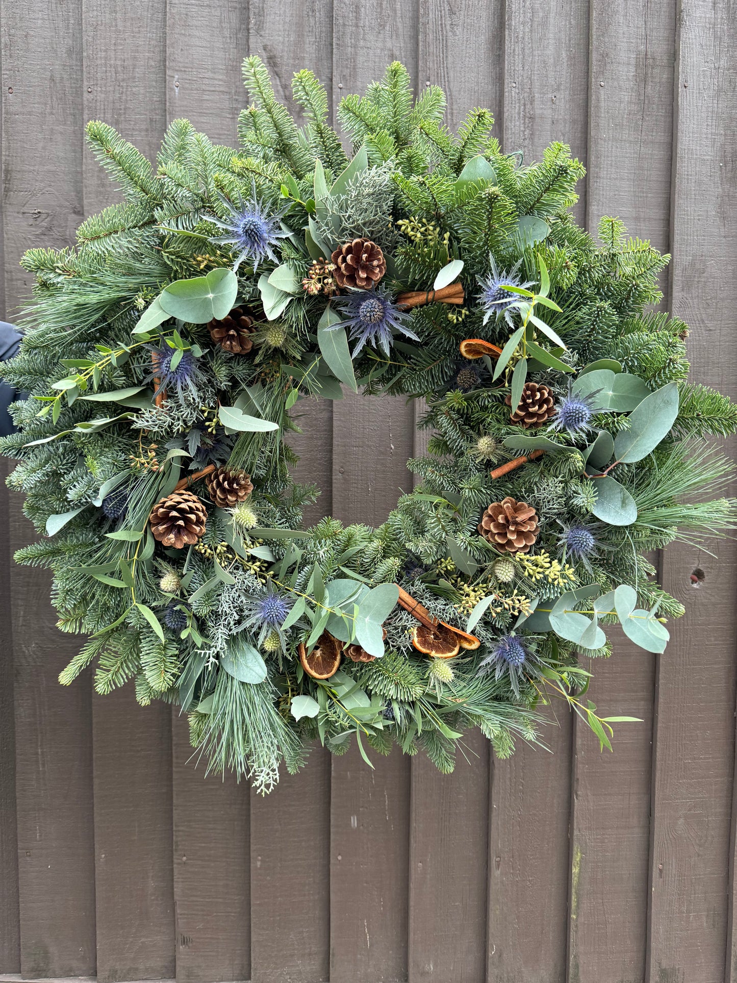 Sea Holly and Pine Christmas Wreath with eucalyptus, spruce, and natural accents – handmade by Barns Florals in Cornwall.